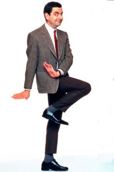 a man in a suit and tie standing on one leg