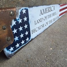 a wooden sign with an american flag and the words america land of the free because of the brave