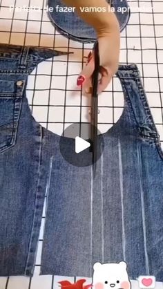 someone using scissors to cut the back of a pair of jeans