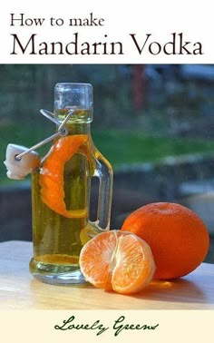 an orange sitting on top of a wooden table next to a bottle of mandarin vodka