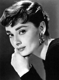 an old black and white photo of a woman with her chin resting on her hand