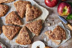 apple pies are arranged on paper next to an apple and some other food items