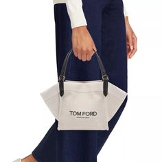 Carry your essentials in style with the Amalfi Small Canvas Tote Bag. From the Amalfi Collection by TOM FORD, this bag is made of durable canvas and features logo lettering for a chic touch. Perfect for everyday use, it's a practical and fashionable choice. Designer Canvas Bag With Removable Pouch For Shopping, Tan Coated Canvas Shoulder Bag, Tan Bucket Bag With Dust Bag For Daily Use, Tan Bags With Dust Bag For On-the-go, Designer Tan Canvas Shoulder Bag, Designer Canvas Bag With Removable Pouch For Daily Use, Chic Coated Canvas Bucket Bag For Shopping, Designer Canvas Bags For On-the-go, Chic Coated Canvas Bag For On-the-go