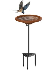 a bird is flying over a table with an upside down plate on it's stand