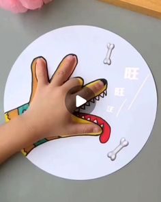 a child's hand on top of a clock with a dog paw and bones