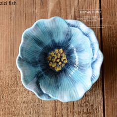 a blue flower sitting on top of a wooden table