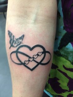 a heart tattoo with two interlocked hearts and a butterfly on the side of the arm