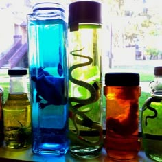 there are many different colored bottles on the window sill