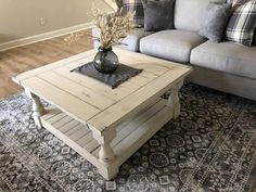 a living room with a couch, coffee table and rug in front of the couch