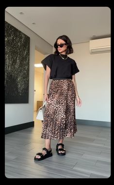 a woman in black shirt and leopard print skirt