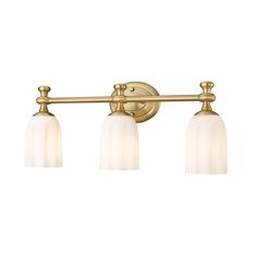 three light bathroom fixture in an antique brass finish with frosted glass shades on the bulbs