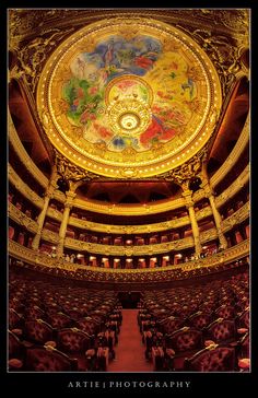 the inside of an ornate theatre with painted ceiling