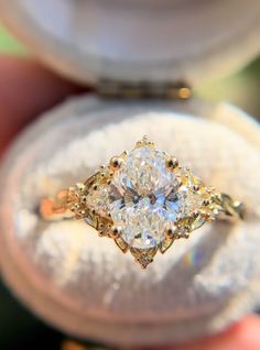 a close up of a person holding a ring with a diamond in it's center