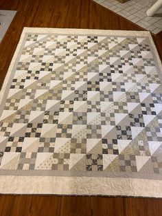 a large quilt is laying on the floor