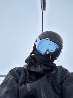 a person wearing ski goggles and a black jacket