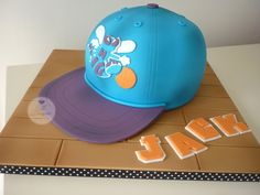 a blue and purple hat sitting on top of a cardboard box next to the word air