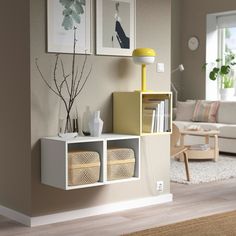 a living room filled with furniture next to a wall mounted book shelf and a lamp