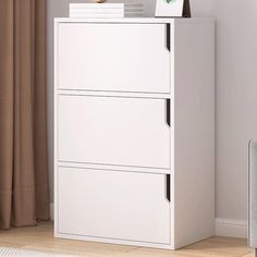 a white filing cabinet with two drawers in front of a window and a rug on the floor