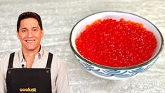 a man in an apron next to a bowl of red beans on a counter top