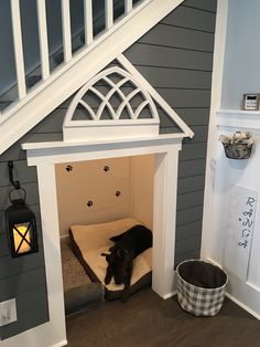 a dog is laying in his bed under the stairs at the top of the stairs