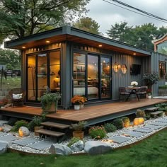 a small house made out of shipping containers in the yard with steps leading up to it