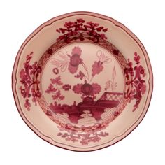 a red and white plate with flowers on it's rim, sitting in front of a white background