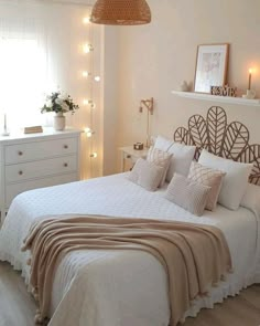 a bed with white sheets and pillows in a bedroom