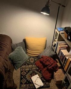 a living room filled with furniture and bookshelves next to a wall mounted lamp