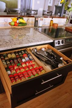 an open drawer in the middle of a kitchen