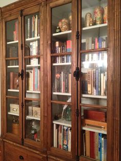 a large wooden bookcase with many books on it's shelves in a living room