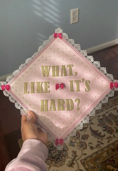 a person holding up a pink and gold sign that says, what like it's hard?