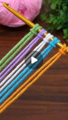 the colorful yarn is being worked on with a crochet hook