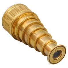 an antique brass telescope lens on a white background