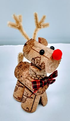 a close up of a stuffed animal made out of wine corks on a white surface