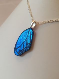 a blue butterfly wing pendant on a silver chain