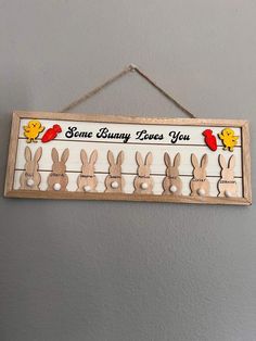 some bunny loves you sign hanging on the wall with wooden pegs attached to it