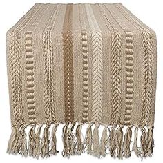 a beige table runner with tassels on it