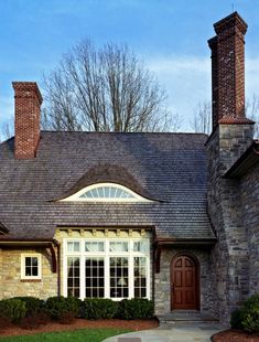 a brick and stone house with two chimneys