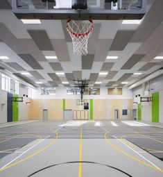 an indoor basketball court with yellow and green lines on the floor is pictured in this image