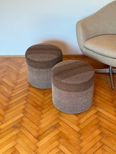 an ottoman and two stools on a wooden floor