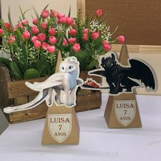 two trophies with flowers in the background and an image of a dragon on one side