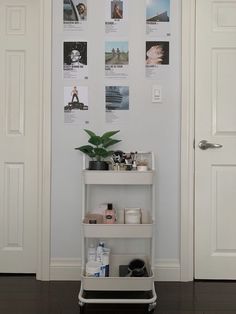 a white shelf with various items on it in front of a door and some doors