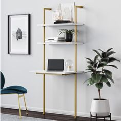 a white desk with a laptop on it next to a potted plant