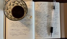 an open notebook with writing and a cup of coffee