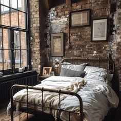 a bed in a room with brick walls and wooden flooring next to a window