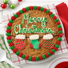 a cookie decorated with christmas decorations on top of a table next to plates and utensils