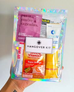 a person holding up a bag with various items inside it, including handover kit and vitamins