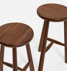 two wooden stools sitting next to each other