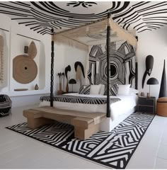 a bed sitting in the middle of a room with black and white decorations on the walls