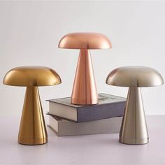 three different colored mushrooms sitting on top of books